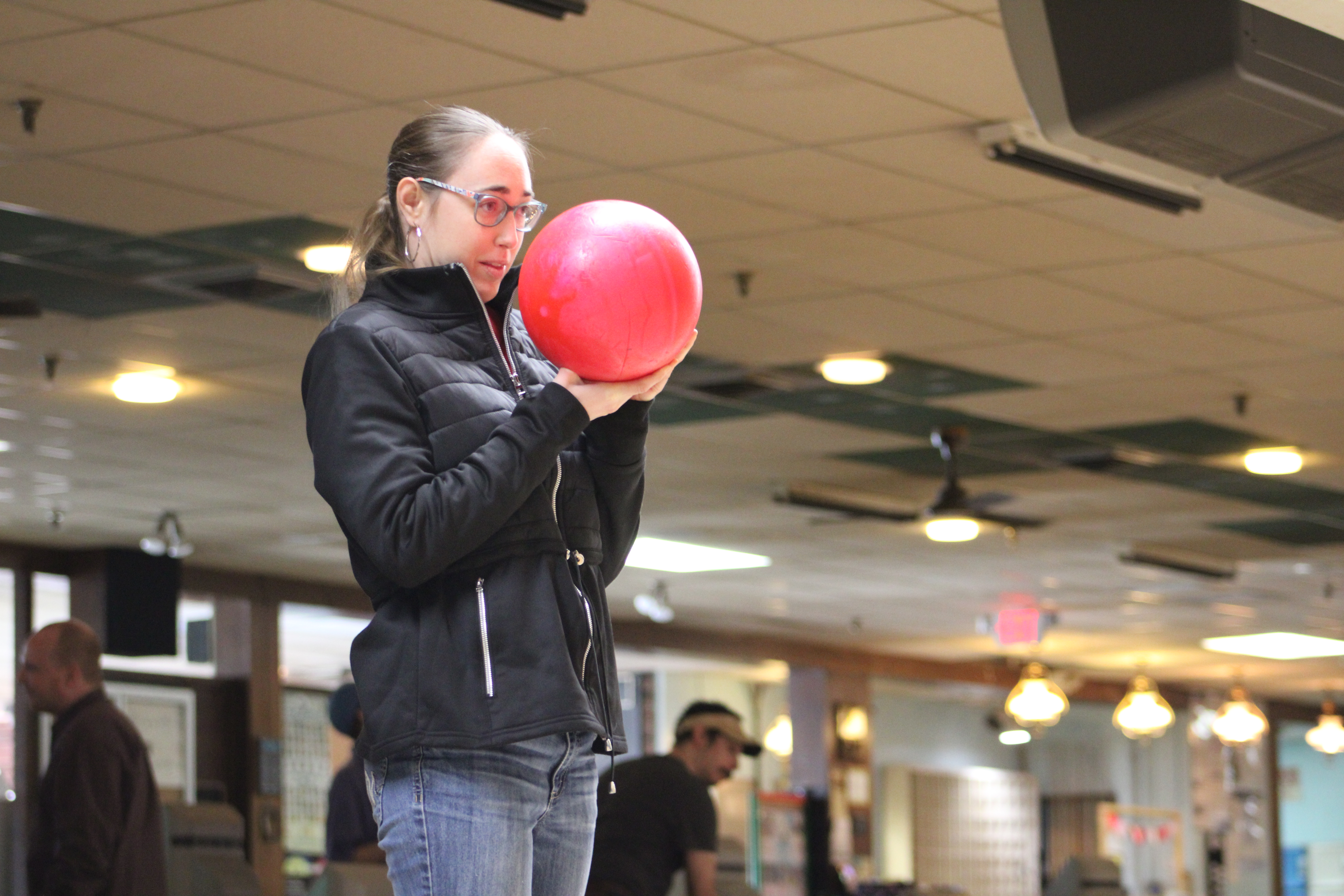 A person holding a red ballDescription automatically generated